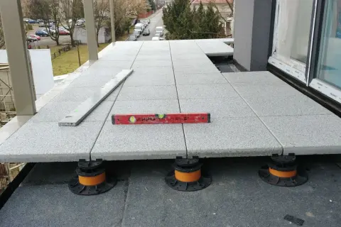 Budowa tarasu wentylowanego. Widać nierówności, które mogą być wadami. Poziomica pokazuje, że prace wymagają poprawy.