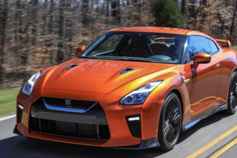 Pomarańczowy Nissan GT-R pędzi po drodze. Sprawdź aktualną nissan gtr cena i poczuj moc!