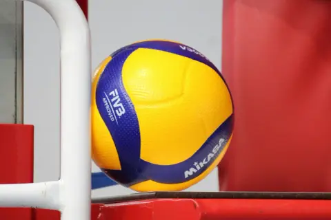 Jaka piłka do siatkówki! Żółto-niebieska Mikasa z oznaczeniem FIVB Approved czeka na grę.