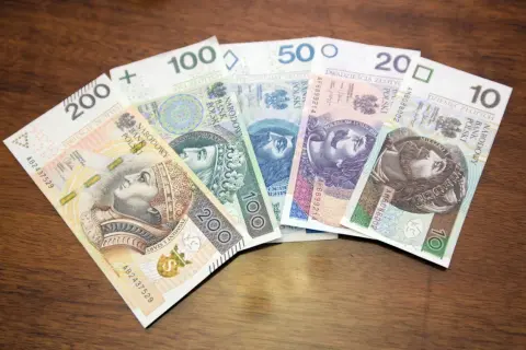 Wycofane banknoty polskie: 200, 100, 50, 20 i 10 złotych leżą na drewnianym blacie.