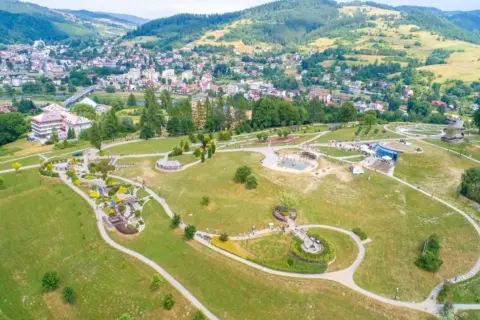 Malowniczy park z alejkami, placem zabaw i wodnymi atrakcjami. W tle widać miasto i góry. To świetne miejsce na rodzinne wycieczki, odkrywając nowe atrakcje Nowego Sącza.