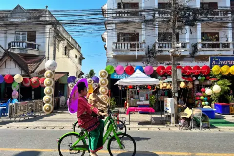 Kolorowe parasolki i tradycyjne stroje w Chiang Mai, gdzie nocować, tworzą festiwalową atmosferę.