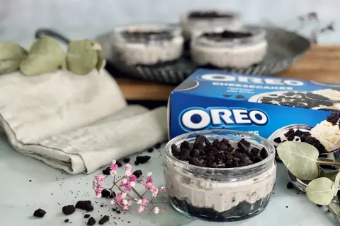 Leckeres Oreo Rezept: Cremige Desserts im Glas, garniert mit zerbröselten Keksen und frischen Kräutern.