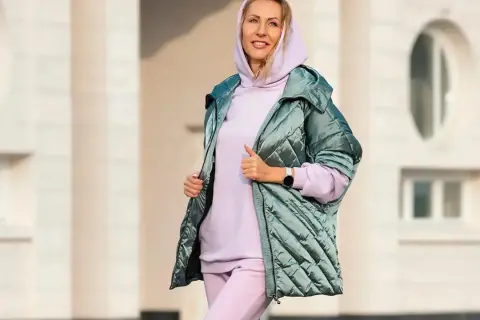 Kobieta w pastelowym dresie i błyszczącej kurtce. Idealny zestaw, który udowadnia, że botki do dresów to świetny wybór na co dzień.