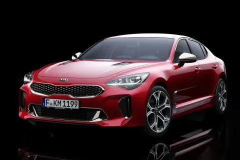 El potente motor del Kia Stinger, un sedán deportivo rojo brillante, se exhibe con su distintiva parrilla y faros LED.