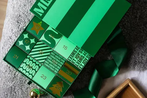 Grön julkalender med siffror och julmotiv. Perfekt som julklappstips för att räkna ner till jul.
