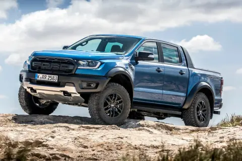 Niebieski Ford Ranger Raptor, terenowy pickup, pokonuje kamienisty szlak. Jego masywna sylwetka i opony sugerują gotowość do wyzwań, jakby był większym bratem modelu ram 2500.
