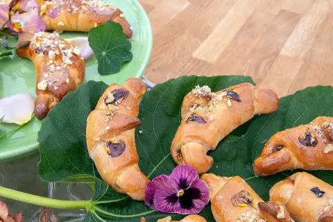 Gyllene gifflar med nötter och torkad frukt, vackert arrangerade på gröna blad. Ett härligt recept på hembakade gifflar!