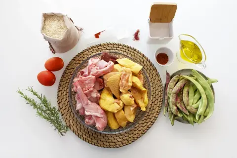 Ingredientes para hacer una paella: arroz, pollo, conejo, judías verdes, tomates, aceite de oliva, pimentón y azafrán.