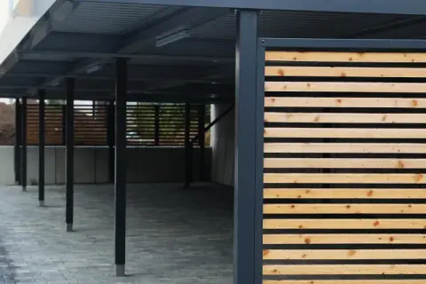 Moderne Holzlamellen verkleiden den Carport und schaffen eine ansprechende Optik.