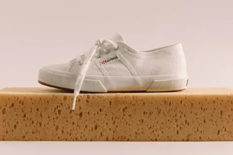 Scarpa bianca Superga su una spugna, pronta per lavare Superga in lavatrice.