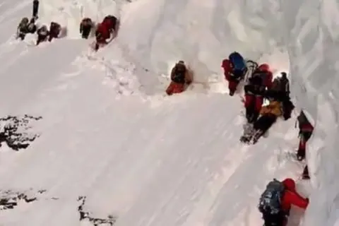 Bergsteiger kämpfen sich durch den steilen, eisigen Flaschenhals am K2.