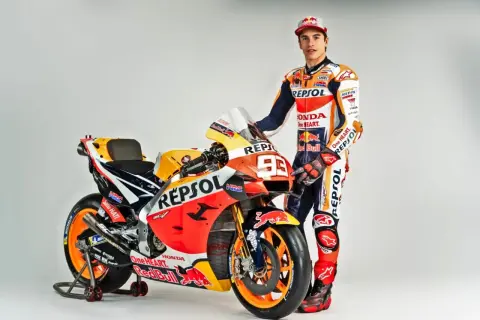 Marc Márquez junto a su moto Repsol Honda, encarnando lo que significa Moto GP: velocidad, pasión y tecnología punta.