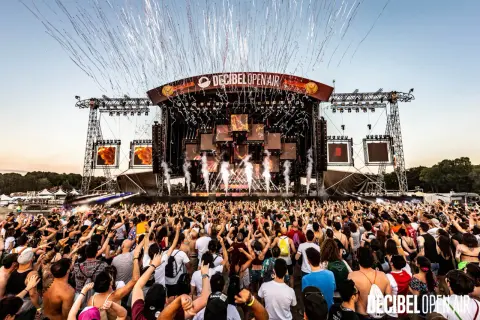 Folla in delirio al Decibel Open Air, con coriandoli e fumo che piovono dal palco. Un evento che celebra i migliori nomi dj techno.