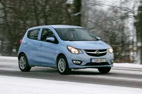 Ljusblå Opel Karl kör på en snöig väg.