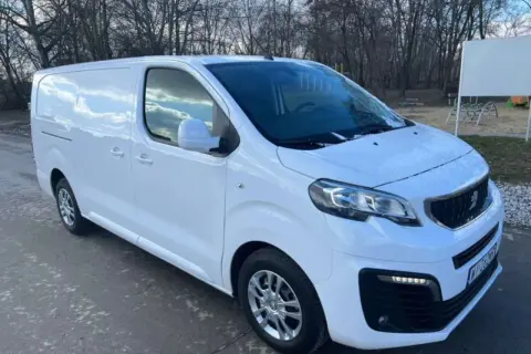 Biały Peugeot Expert 2.0 HDI gotowy do pracy. W tle drzewa i plac zabaw.