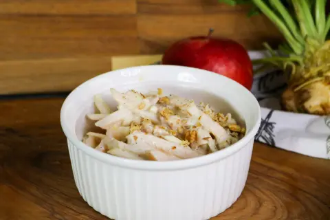 Cremiger Selleriesalat mit Walnüssen, ein köstliches selleriesalat rezept, serviert in einer weißen Schüssel.