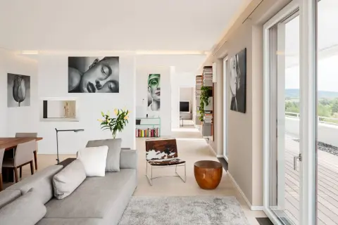 Ein heller Wohnraum mit Kunstwerken, wie sieht die Farbe Beige aus, die Wände und der Boden sind in diesem warmen Ton gehalten.
