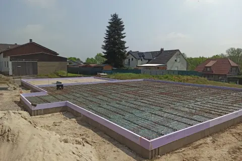 Fundament pod dom w Niemczech, gotowy do zalania betonem. Praca na budowlance trwa.
