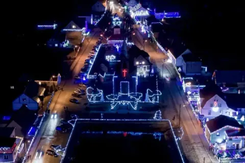 Nocne Popowo rozświetlone tysiącami światełek. Kościół i domy ozdobione świątecznymi iluminacjami tworzą magiczny widok.