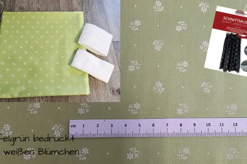 Apfelgrüner Stoff mit weißen Blümchen, ideal für eine Dirndlschürze. Ein Schnittmuster liegt bei.