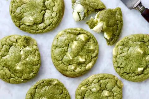 Des cookies clairs au matcha, parsemés de morceaux de chocolat blanc, prêts à être dégustés. Un délice vert et blanc.