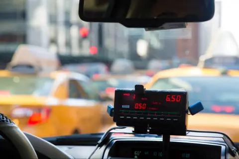 Taksometr w żółtej taksówce pokazuje 6.50. Zastanawiasz się, ile kosztuje taxi za 50 km?