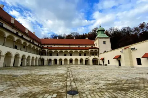 Dziedziniec zamku Sucha Beskidzka z arkadowymi krużgankami i wieżą.