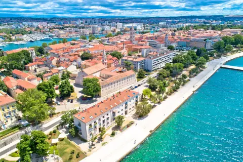 Zadar we wrześniu: słoneczna pogoda, turkusowe morze i urokliwe miasto z czerwonymi dachami. Idealne miejsce na wakacje.