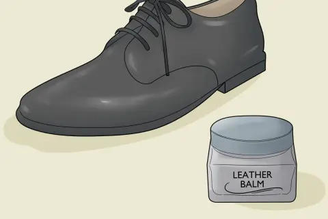 Un soulier en cuir noir et un pot de baume pour cuir. Apprenez comment assouplir des chaussures en cuir pour un confort optimal.