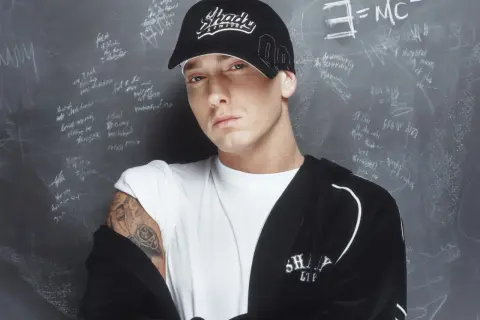 Eminem, der erfolgreichste Rapper, trägt eine "Shady"-Kappe vor einer Tafel mit Formeln und Texten.