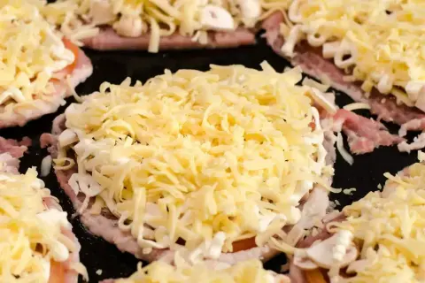 Schab w plastrach z pieczarkami i serem, gotowy do zapieczenia. Idealny pomysł, co zrobić ze schabu w plastrach na szybki obiad.