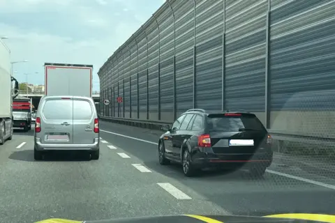 Korek na autostradzie, samochody i ciężarówki stoją w rzędzie. Kierowcy powinni pamiętać o jazda na suwak przepisy, by płynnie włączyć się do ruchu.