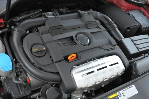 Silnik 1.4 TSI z widocznym logo VW. Widoczne elementy układu dolotowego i osłony silnika.