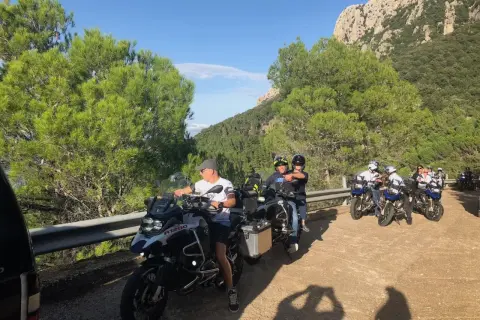Grupa motocyklistów na drodze z pięknymi widokami, podróż motocyklem po Sardynii.