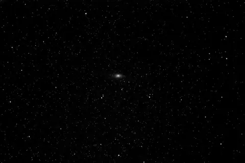Mglista smuga galaktyki Andromeda na tle gwiezdnego nieba.