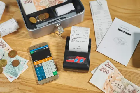 Kasa fiskalna, smartfon z kalkulatorem, banknoty i monety. Kto musi mieć kasę fiskalną? Sprawdź przepisy!