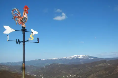 Gallo segnavento su sfondo di montagne innevate in Valmarecchia. Scopri cosa vedere in questa splendida cornice naturale.