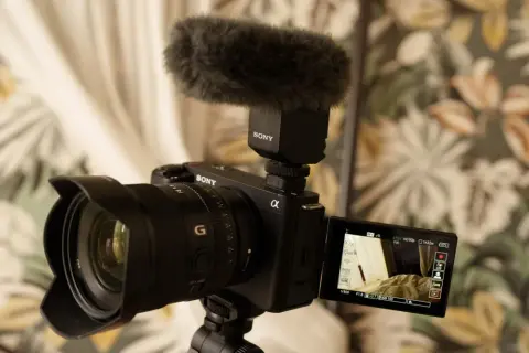 Kamera Sony Alpha z mikrofonem na gorącej stopce, gotowa do nagrywania. Idealny sprzęt do tworzenia treści, np. vlogów.