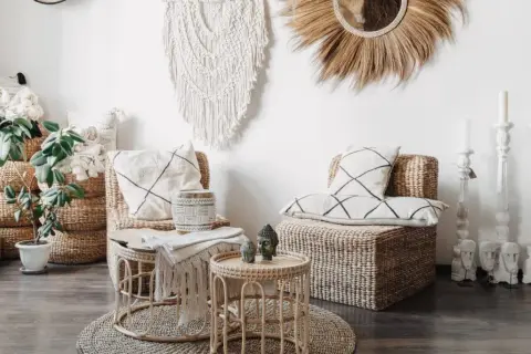 Przytulne wnętrze w stylu scandi boho: wiklinowe meble, makrama, poduszki z geometrycznymi wzorami i rośliny tworzą relaksującą atmosferę.