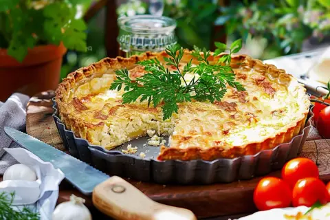 En gyllene paj med en härlig glutenfri pajdeg, fylld med ost och örter. Serveras med färska tomater och lök.