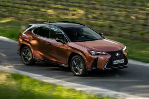 Miedziany Lexus UX na krętej drodze, idealny do miasta. Sprawdź nasze lexus ux opinie!