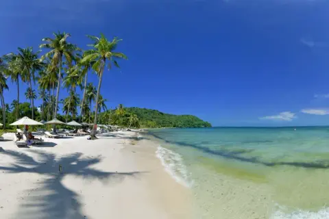 Rajska plaża na Phu Quoc, z palmami, leżakami i turkusową wodą. Czy warto tu przyjechać? Zdecydowanie tak!