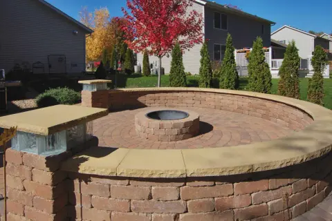 A circular brick patio features an in-ground fire pit, perfect for cozy evenings.