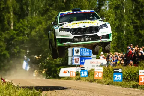 Skoda Fabia Rally 2 w locie nad ziemią, z widownią w tle.