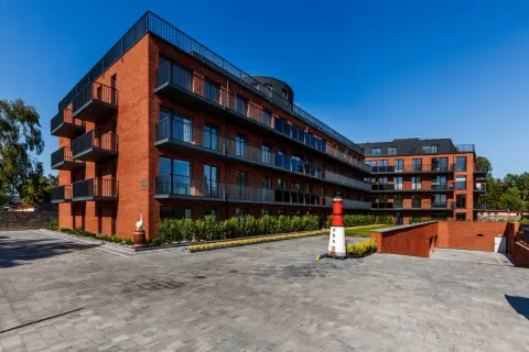 Nowoczesne apartamenty Jastrzębia Góra z balkonami i widokiem na morze. Obok latarnia morska.
