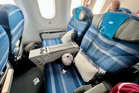 Komfortowe fotele w klasie premium economy LOT. Poduszka i koc czekają na pasażera.
