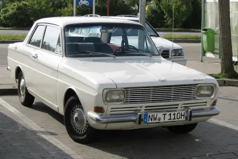 Vit Ford Taunus 12M från 1960-talet parkerad utomhus. Bilen har en klassisk design med kromade detaljer.