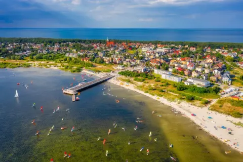 Jastarnia atrakcje: wiatr, deski i słońce na Zatoce Puckiej. Widok na molo, plażę i miasteczko.
