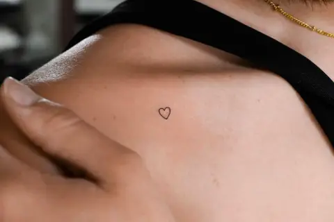 Ein zartes Herz-Tattoo auf der Schulter. Coole Tattoo Motive einfach und minimalistisch, perfekt für einen subtilen Ausdruck von Liebe.